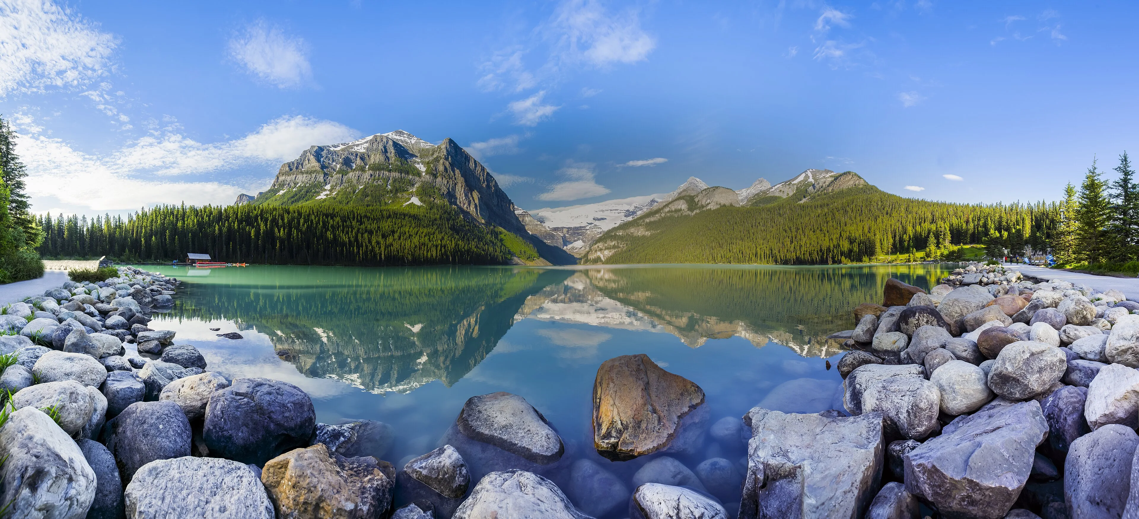 A broad view over a turquoise lake and mountain peaks in the Canadian Rockies